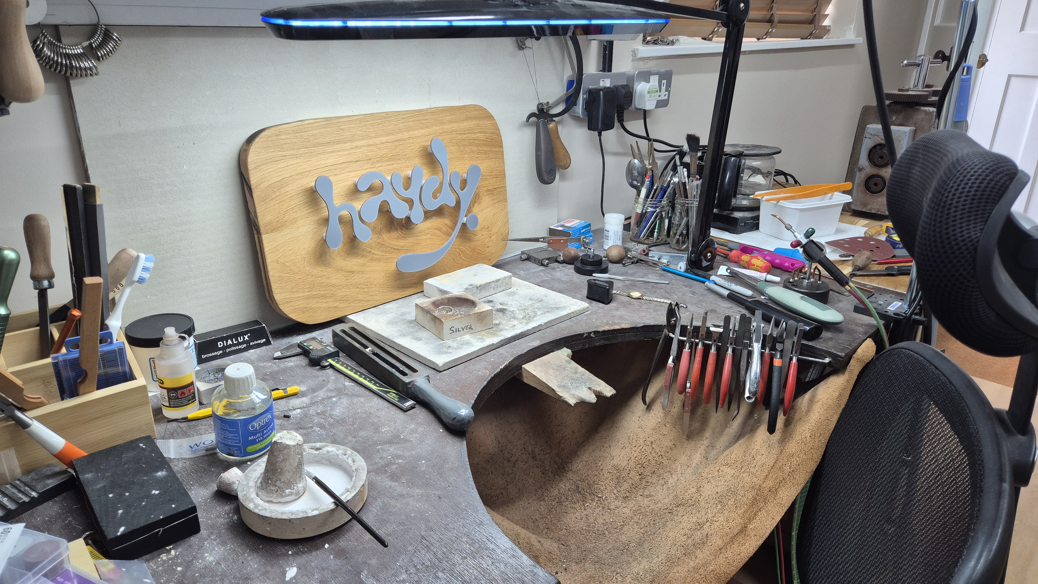 Adrian's workbench in Findon Valley: leather catch apron, hand tools, pliers and files, with the chair pulled back