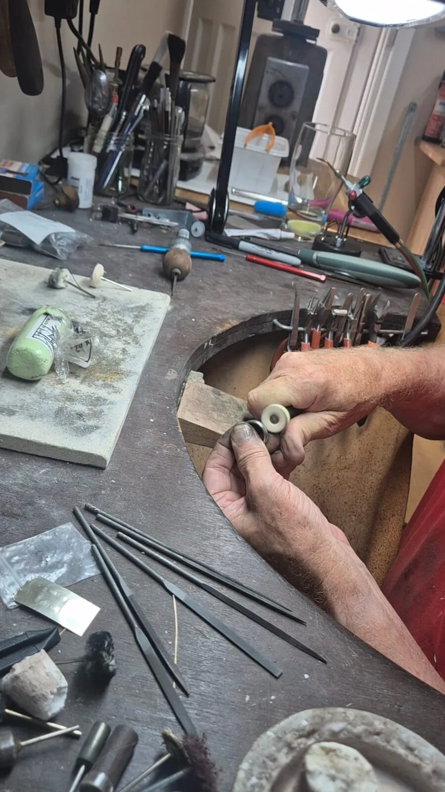 A ring being polished at the bench, files and tools alongside